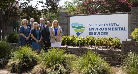 SCDES staff in front of sign